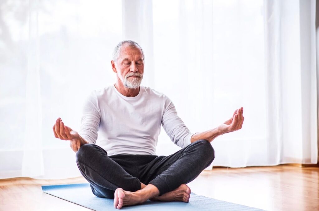 Senior man meditating in home